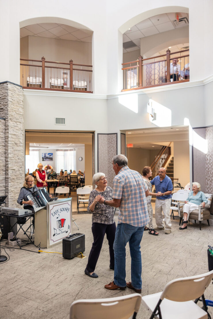 Residents enjoy a lively dance event, fostering joy and connection in a warm, inviting atmosphere.