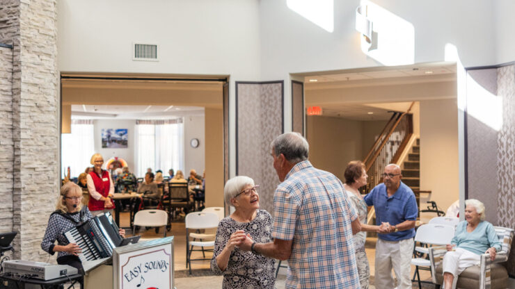 Residents enjoy a lively dance event, fostering joy and connection in a warm, inviting atmosphere.