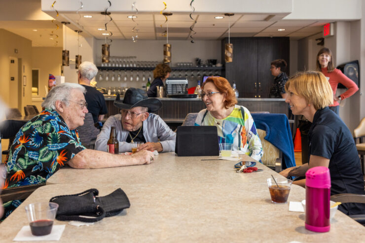 Residents enjoy lively conversations over refreshments in a welcoming community lounge.