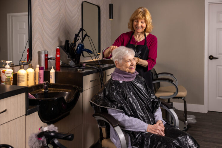A warm salon atmosphere where residents enjoy personal care and friendly companionship.