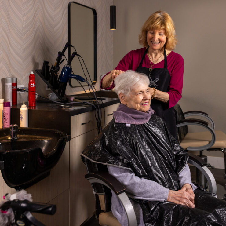 A warm salon atmosphere where residents enjoy personal care and friendly companionship.