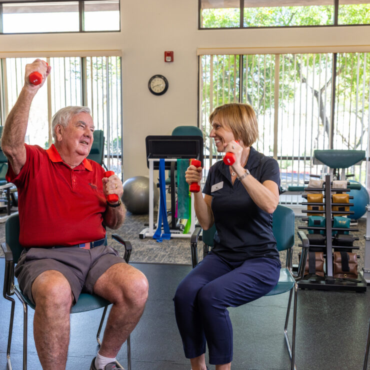 Engaging seniors enjoy a lighthearted fitness session, fostering community and well-being in a bright, inviting space.