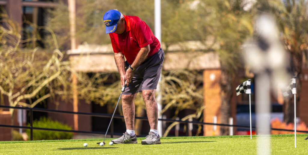 A resident enjoys a sunny day practicing golf, fostering camaraderie and active living in the community.