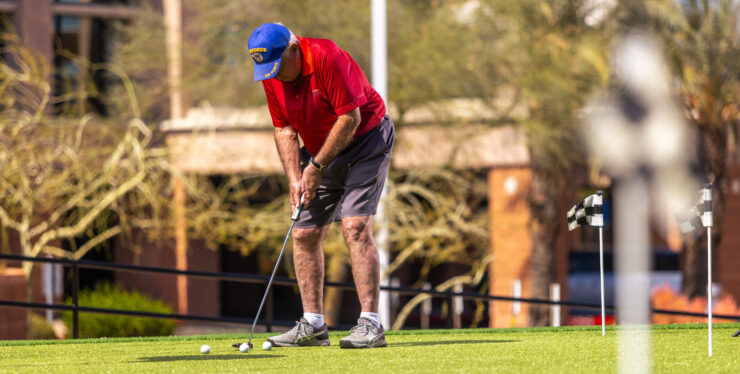 A resident enjoys a sunny day practicing golf, fostering camaraderie and active living in the community.
