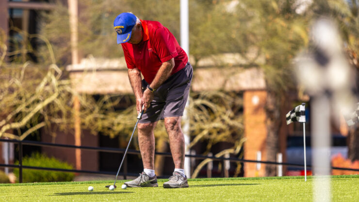 A resident enjoys a sunny day practicing golf, fostering camaraderie and active living in the community.