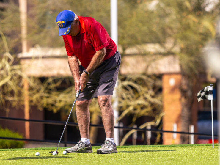 A resident enjoys a sunny day practicing golf, fostering camaraderie and active living in the community.