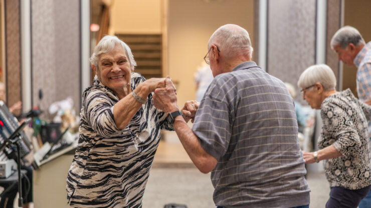 Residents joyfully dance together, celebrating community and connection in a vibrant atmosphere.