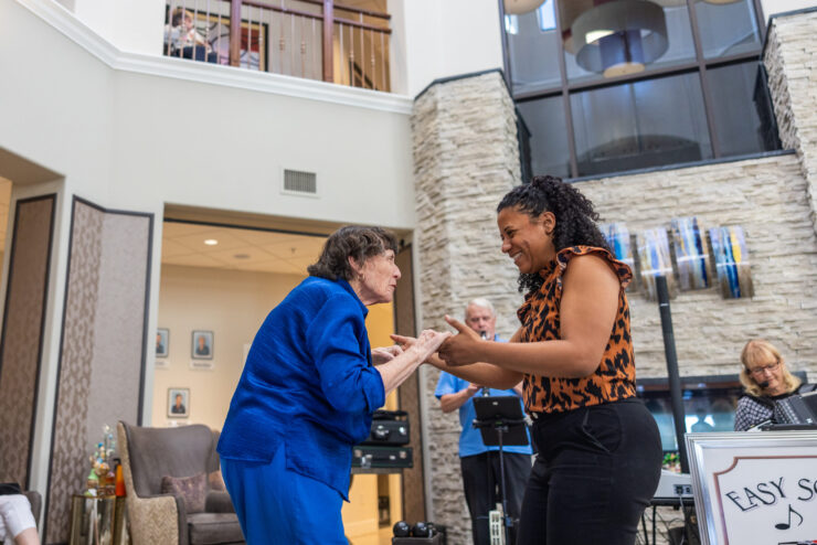 A vibrant gathering fosters joy and connection, with residents engaging warmly in dance and music.