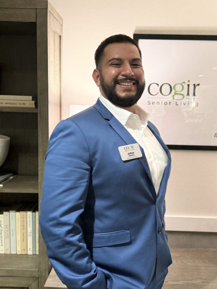 A friendly staff member in professional attire stands proudly, embodying warmth and community spirit.