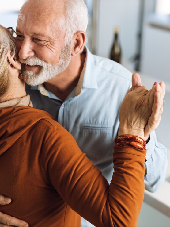 A joyful couple shares a heartfelt embrace, radiating warmth and connection in a welcoming home.