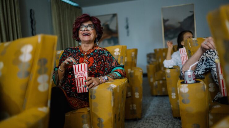 Residents enjoy a lively movie night, sharing laughter and popcorn in a vibrant, welcoming space.