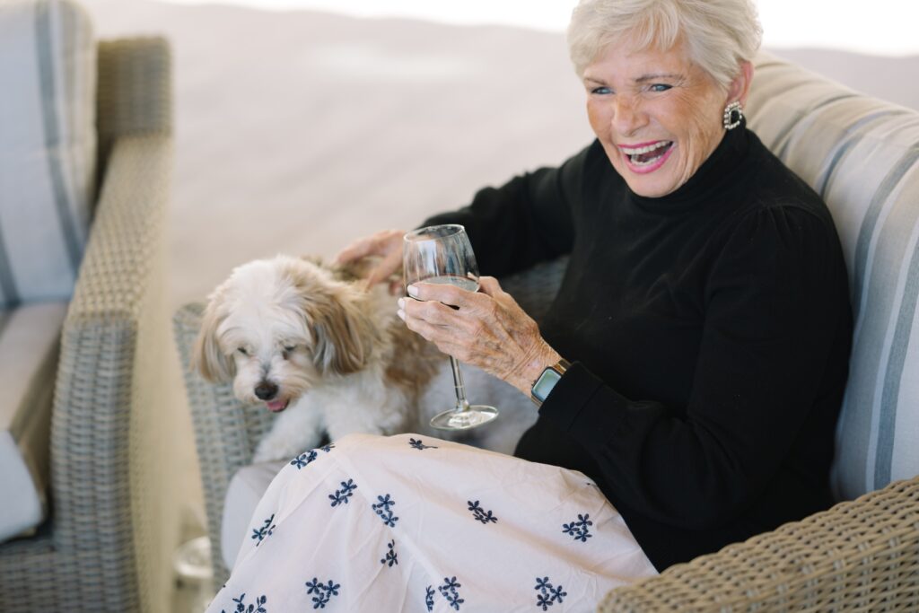 A joyful resident enjoys a drink with her furry companion, embodying warmth and community spirit.