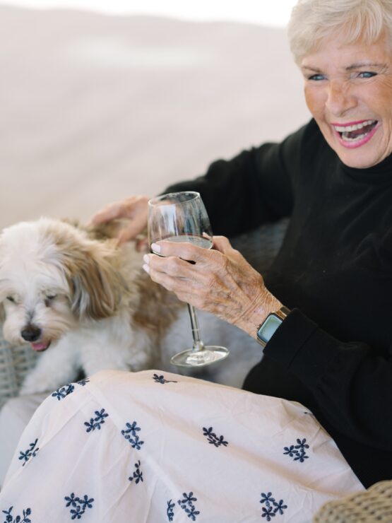 A joyful resident enjoys a drink with her furry companion, embodying warmth and community spirit.