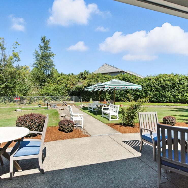 A serene garden setting with comfortable seating invites community and relaxation under a bright sky.