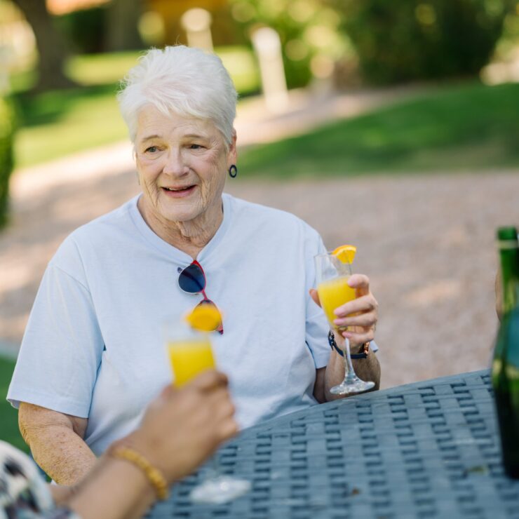Lively conversation and laughter fill the air as friends enjoy refreshing drinks in a beautiful outdoor setting.