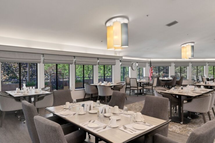 Bright dining area with elegant tables, inviting ambiance, and large windows fostering community connections.