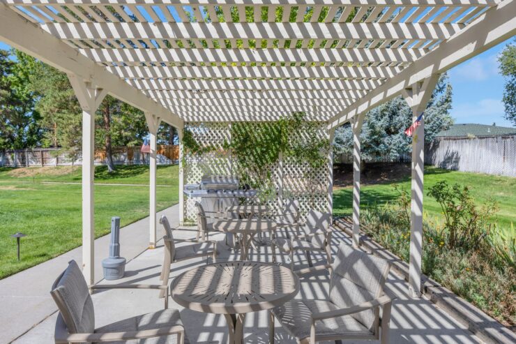 A welcoming outdoor space with shaded seating, perfect for community gatherings and relaxation.