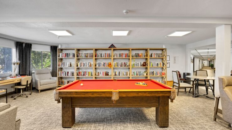 A welcoming activity space featuring a vibrant pool table and inviting seating, perfect for community gatherings.
