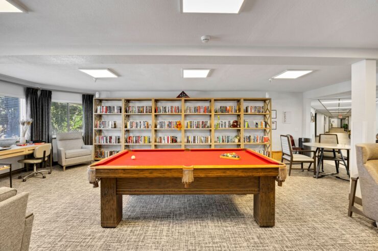 A welcoming activity space featuring a vibrant pool table and inviting seating, perfect for community gatherings.
