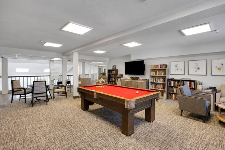 A welcoming lounge area features a vibrant pool table, inviting relaxation and friendly gatherings.