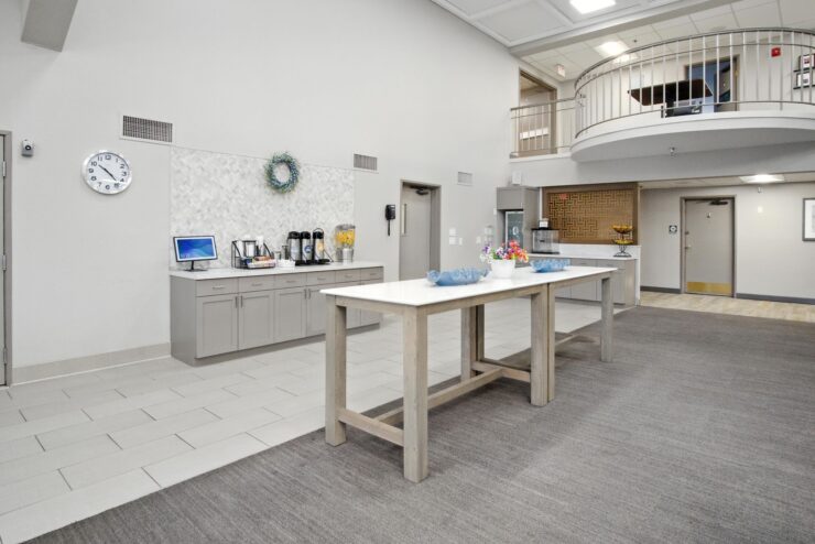 A welcoming common area featuring a spacious table, coffee station, and vibrant decor, fostering community.