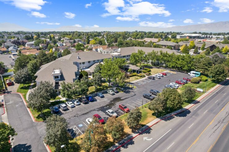 A welcoming community surrounded by greenery, featuring a spacious parking area and comfortable living spaces.