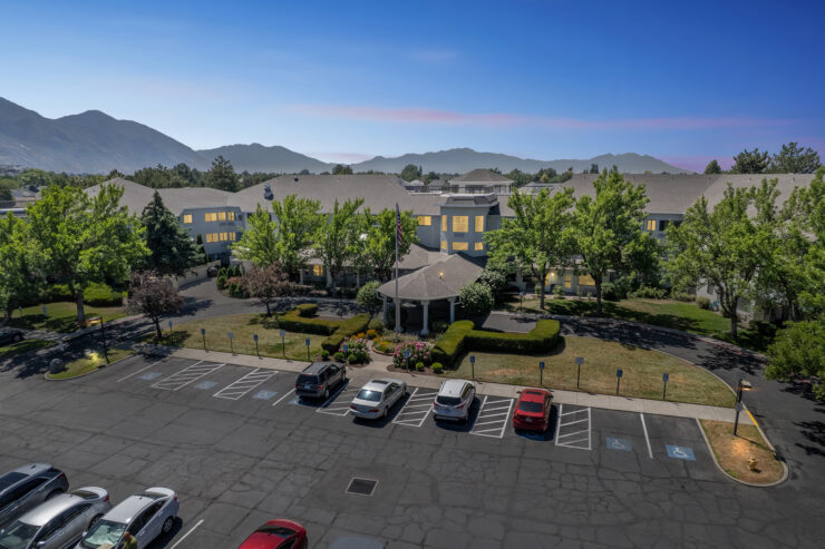 A welcoming retirement community surrounded by beautiful landscaping and serene mountains.