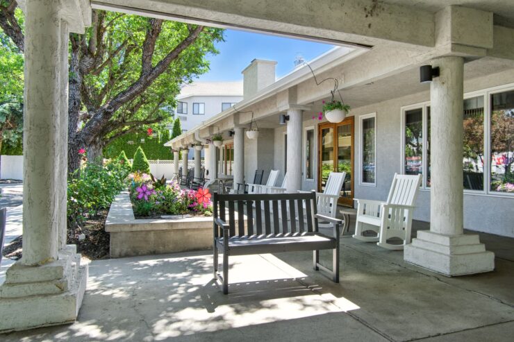 A welcoming outdoor space with shaded seating and vibrant flowers, perfect for community gatherings.