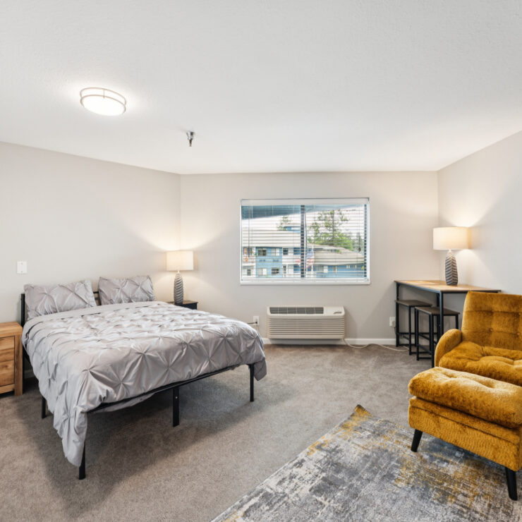A welcoming bedroom with soft lighting, inviting furnishings, and a serene view, perfect for relaxation.