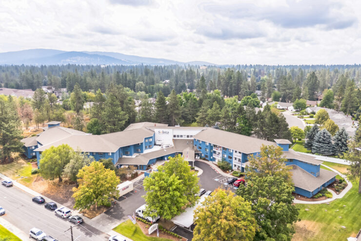 A welcoming retirement community surrounded by lush greenery, promoting comfort and connection.
