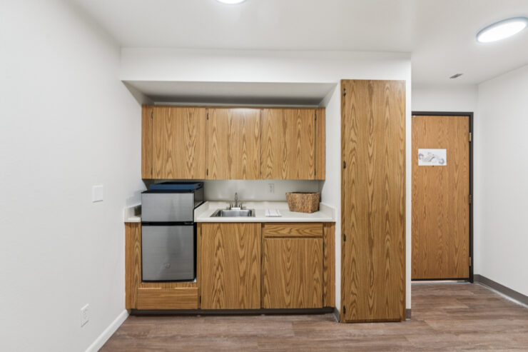 A welcoming kitchen space with warm wood cabinetry, fostering community and comfort for residents.