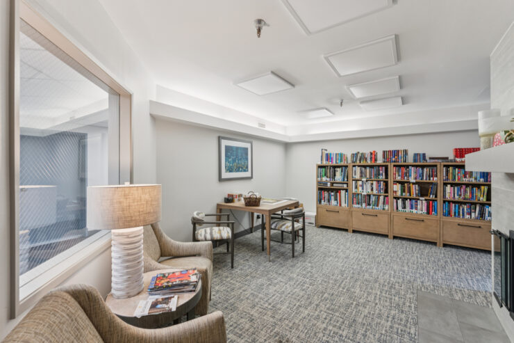 A welcoming reading nook featuring comfortable seating, bookshelves, and warm lighting for community engagement.