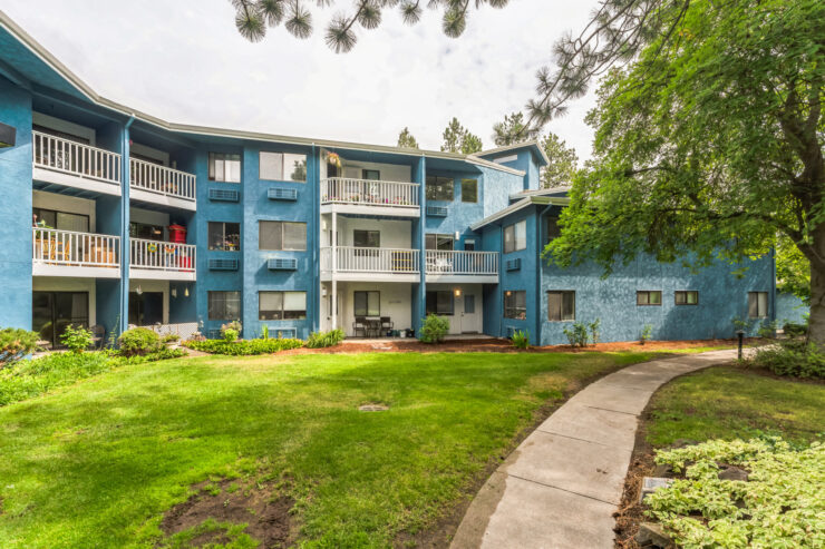 A welcoming community surrounded by greenery, featuring comfortable living spaces and a peaceful pathway.