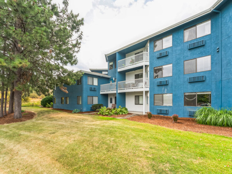 A welcoming community space featuring a vibrant blue building surrounded by lush greenery.
