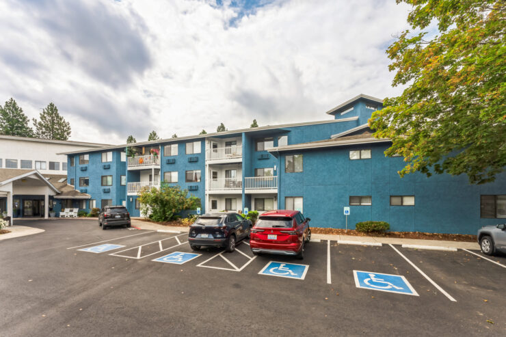 A welcoming community with vibrant blue buildings and accessible parking, perfect for relaxed living.