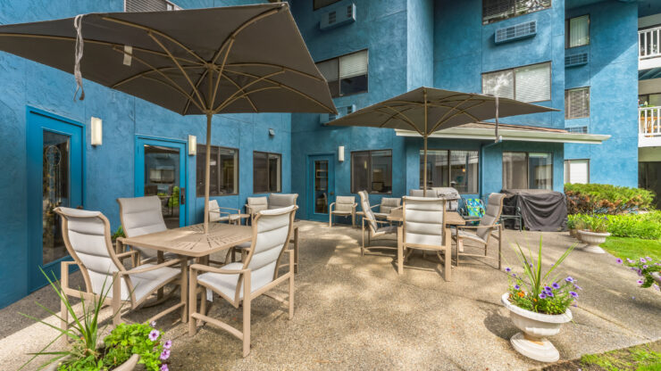 A welcoming outdoor space featuring comfortable seating and vibrant greenery, perfect for community gatherings.