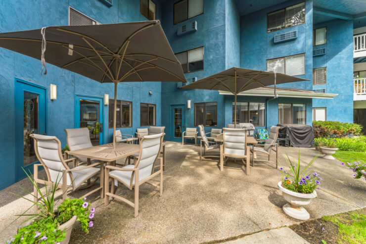 A welcoming outdoor space featuring comfortable seating and vibrant greenery, perfect for community gatherings.