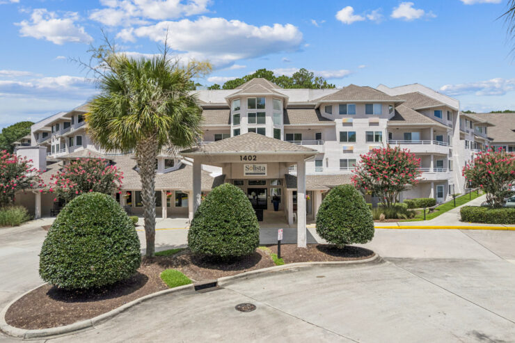 A welcoming entrance surrounded by lush greenery, inviting residents to enjoy a vibrant community.