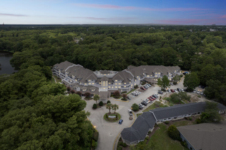 A welcoming retirement community nestled among lush greenery, fostering connection and tranquility.