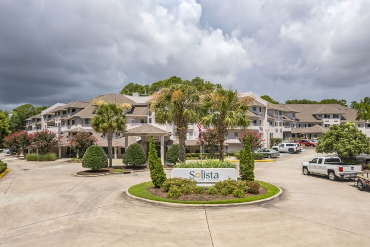 A welcoming retirement community surrounded by lush greenery and inviting spaces for connection.