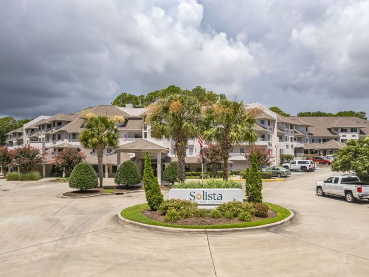 A welcoming retirement community surrounded by lush greenery and inviting spaces for connection.