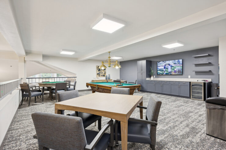 A welcoming common area featuring comfortable seating, a billiards table, and a friendly atmosphere.