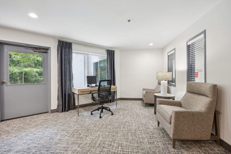 Bright, inviting space featuring comfortable seating and a desk, perfect for relaxation and community.