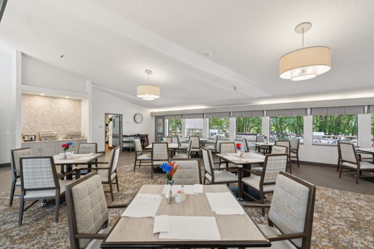 Bright dining area with inviting tables, flowers, and natural light, fostering a sense of community.