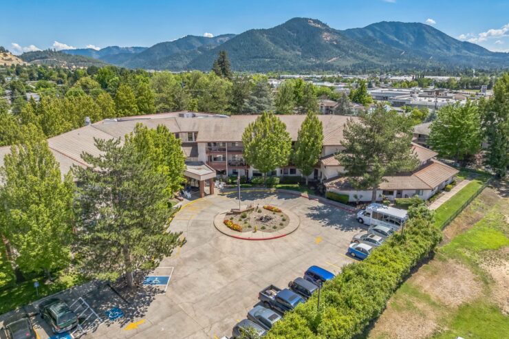 A welcoming retirement community nestled among lush greenery and scenic mountains, promoting comfort and connection.