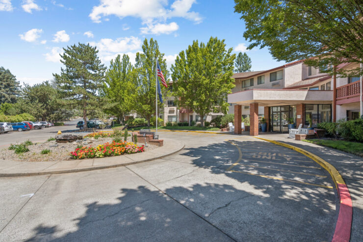 A welcoming entrance surrounded by lush greenery and vibrant flowers, inviting community and connection.
