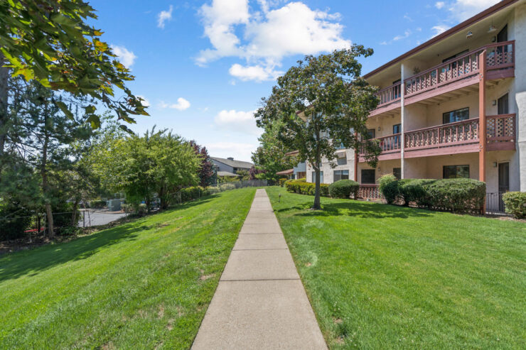 A serene pathway lined with greenery, inviting residents to enjoy leisurely strolls in a welcoming community.
