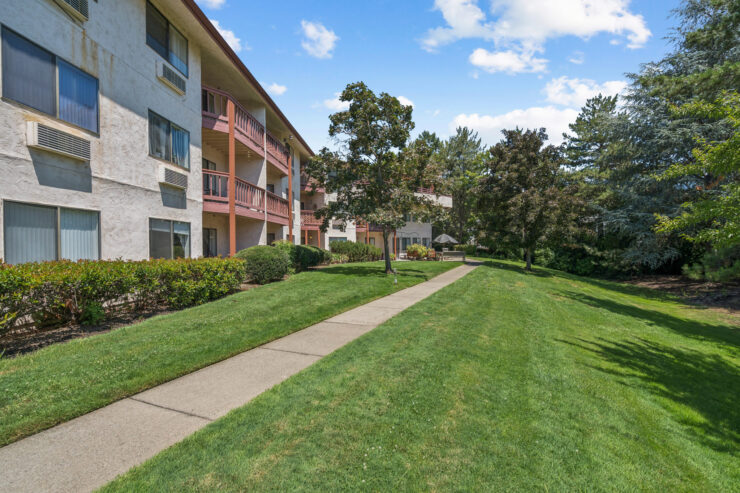 A serene pathway winds through vibrant greenery, inviting residents to enjoy their peaceful community.