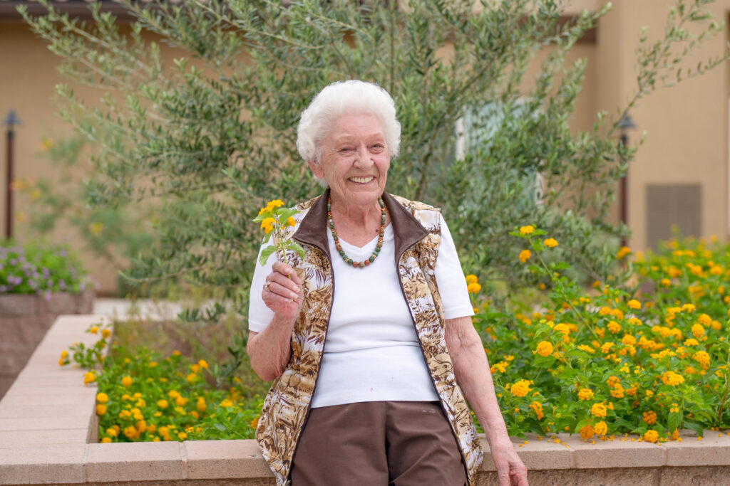 A joyful resident enjoys the vibrant garden, embodying warmth and community spirit.