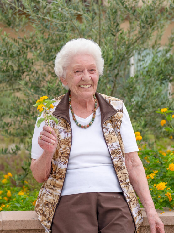A joyful resident enjoys the vibrant garden, embodying warmth and community spirit.